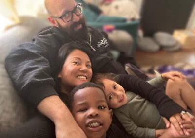 interracial family smiling on couch