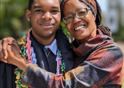 black woman hugging black man in graduation gown